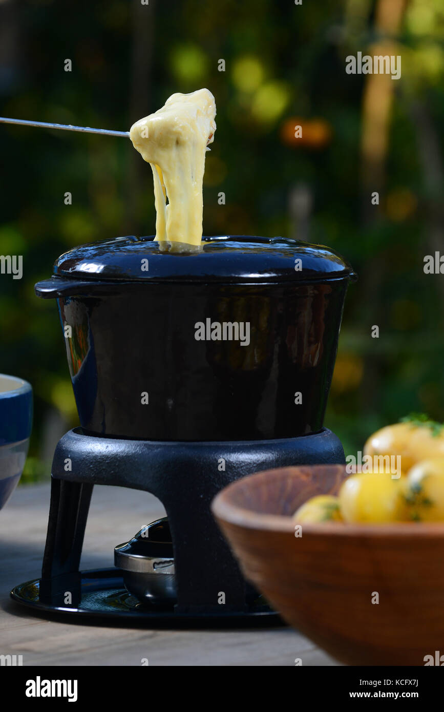 A cheese fondue with boiled potatoes, bread and salad Stock Photo Alamy