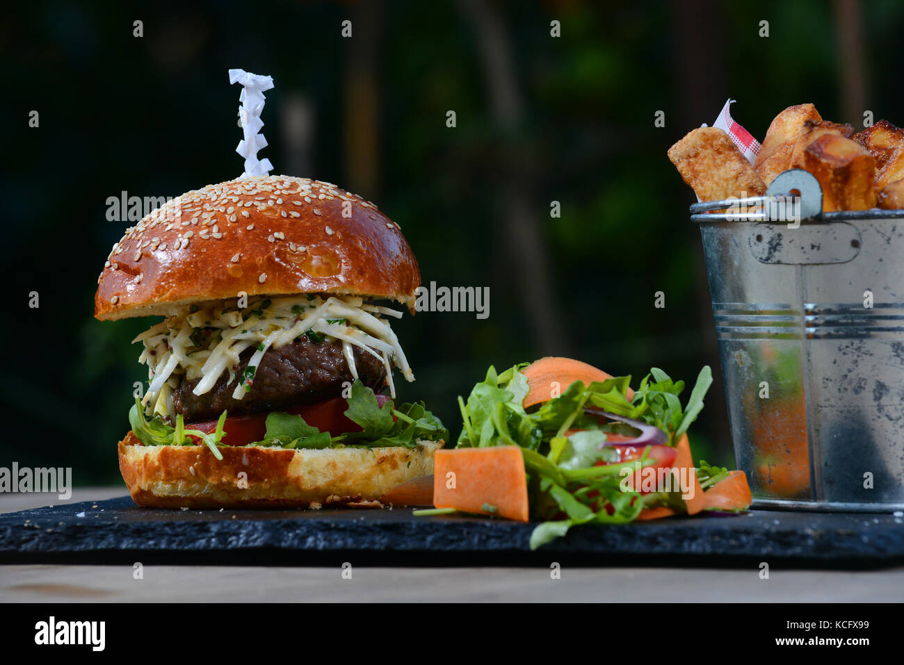 Cheeseburger with tomato, rocket, salad, coleslaw in a brioche bun and