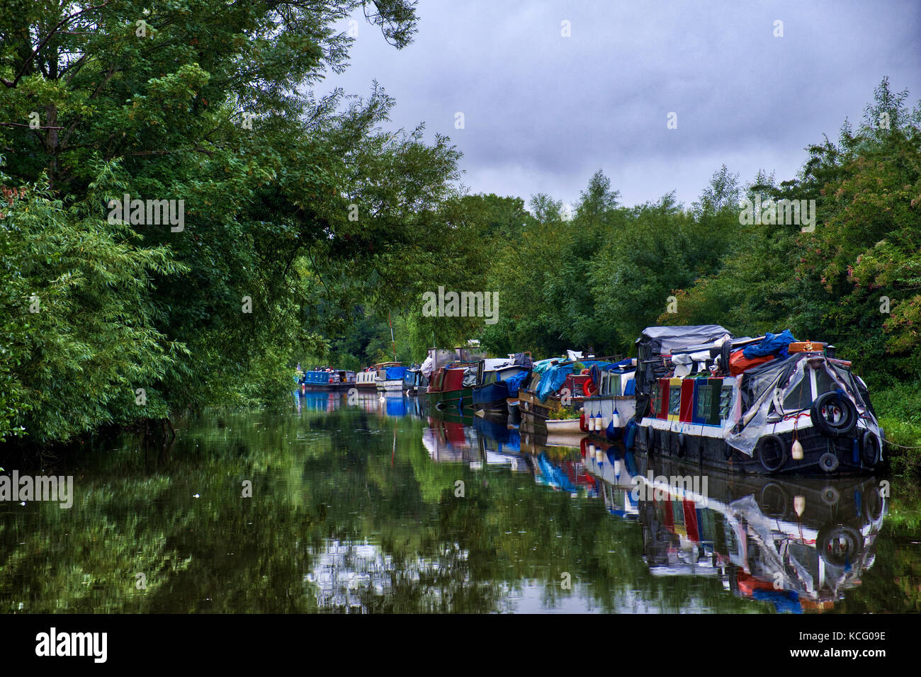 Colourful houseboats moored along the Grand Union Canal at