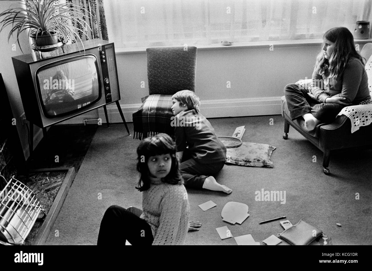 Children watching TV television at home interior living room family life 1970s. Ethnic diversity BAME child 1972. Middle class family home Leicestershire UK HOMER SYKES Stock Photo