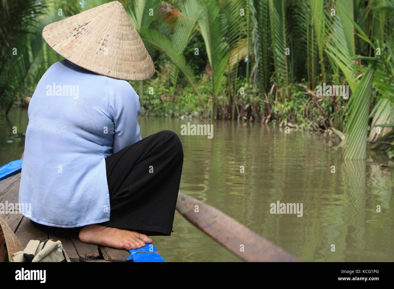 Frau auf Boot beim Rudern in Vietnam - Woman on boat while rowing in Vietnam Stock Photo