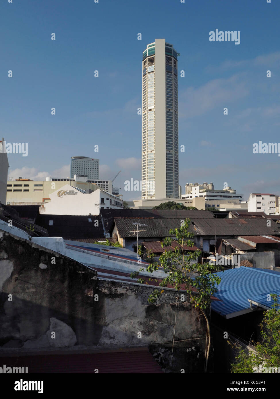 Modern Komtar Tower in Penang, Malaysia. Old traditional building in foreground. Stock Photo