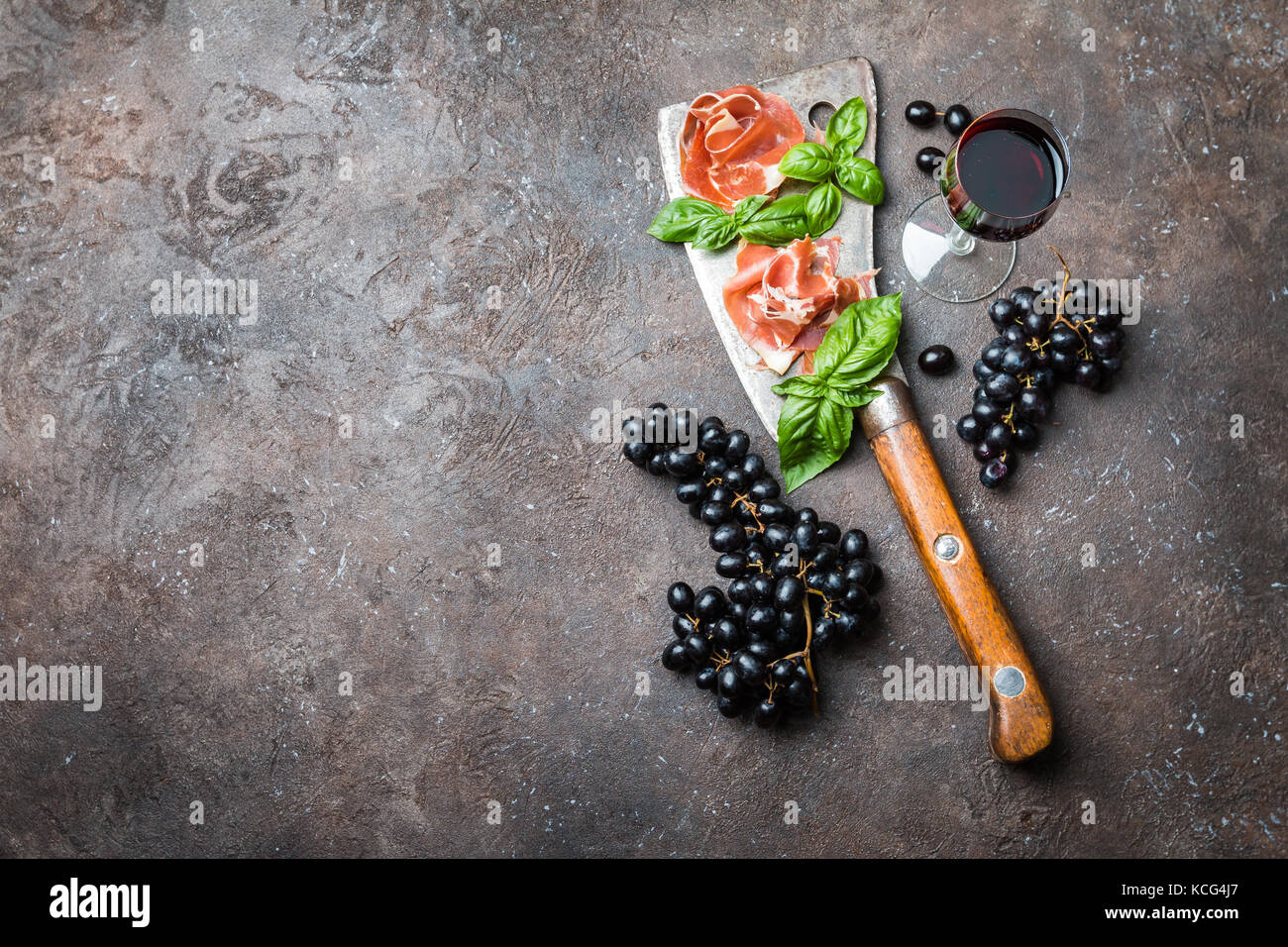 Sliced jamon with butcher knife, grapes and wine. Parma ham hamon on
