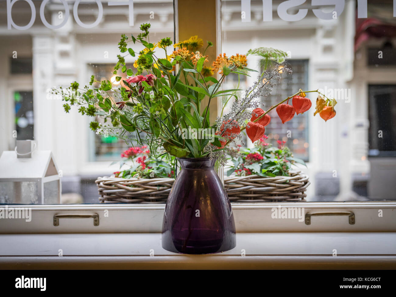 A vase with a colourful flower bouquet in the window with view to the street in Utrecht, the Netherlands Stock Photo