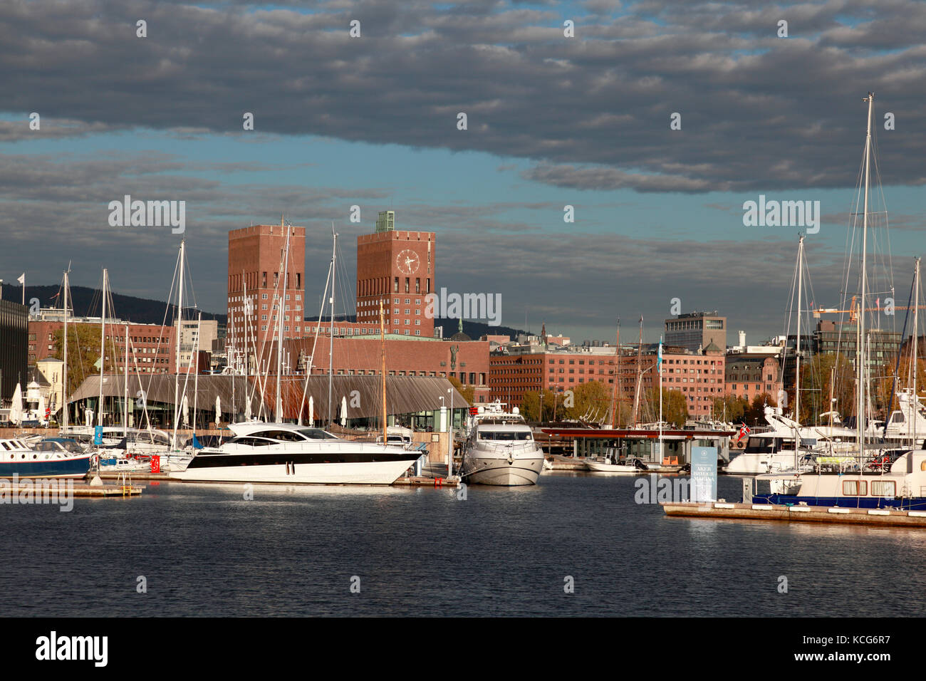 The brick towers of Oslo Town Hall and the waterfront of Aker Brygge Marina in Oslo, Norway Stock Photo