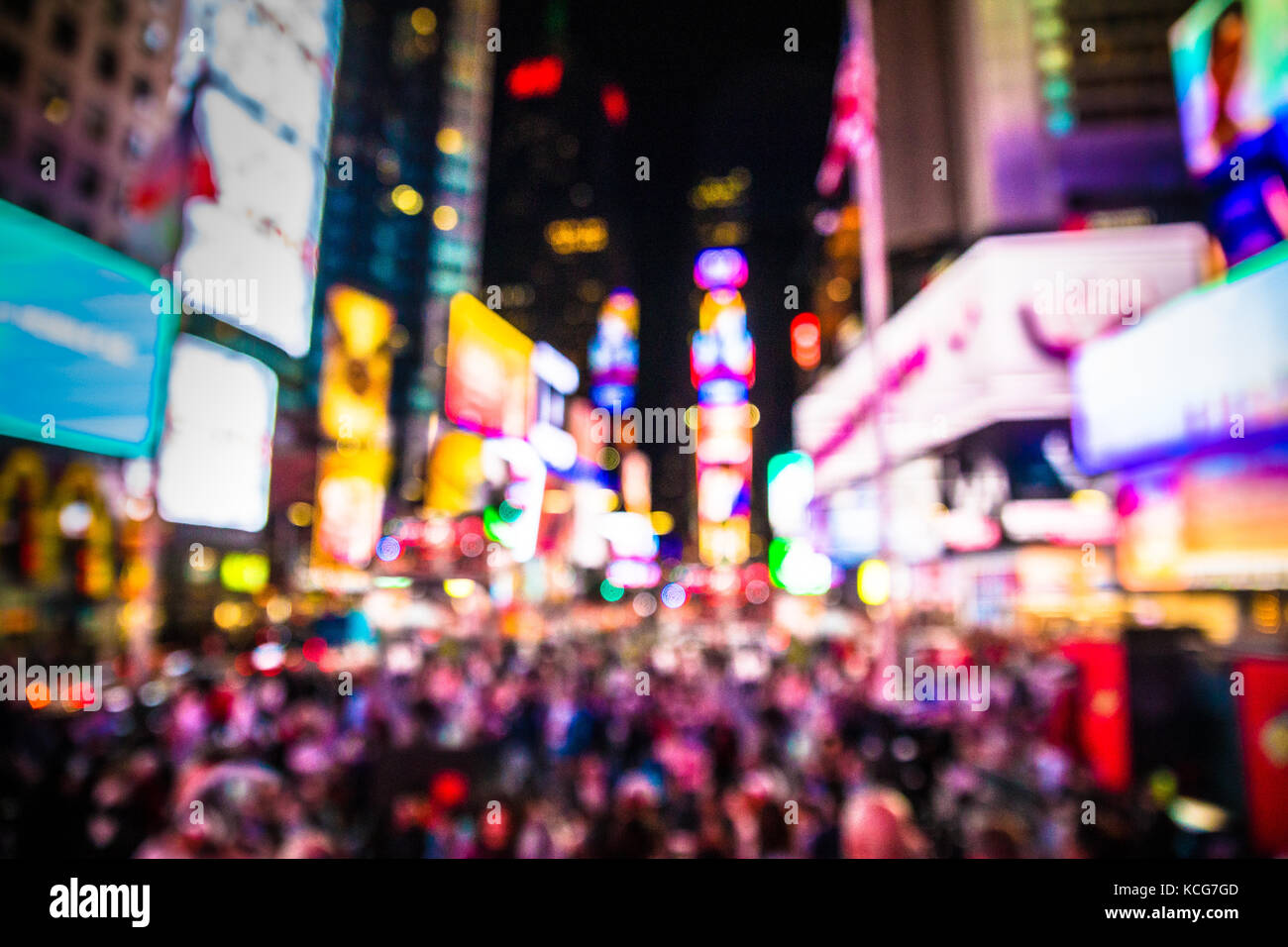 Defocused blur of Times Square in New York City, midtown Manhattan at night with lights and people. Stock Photo