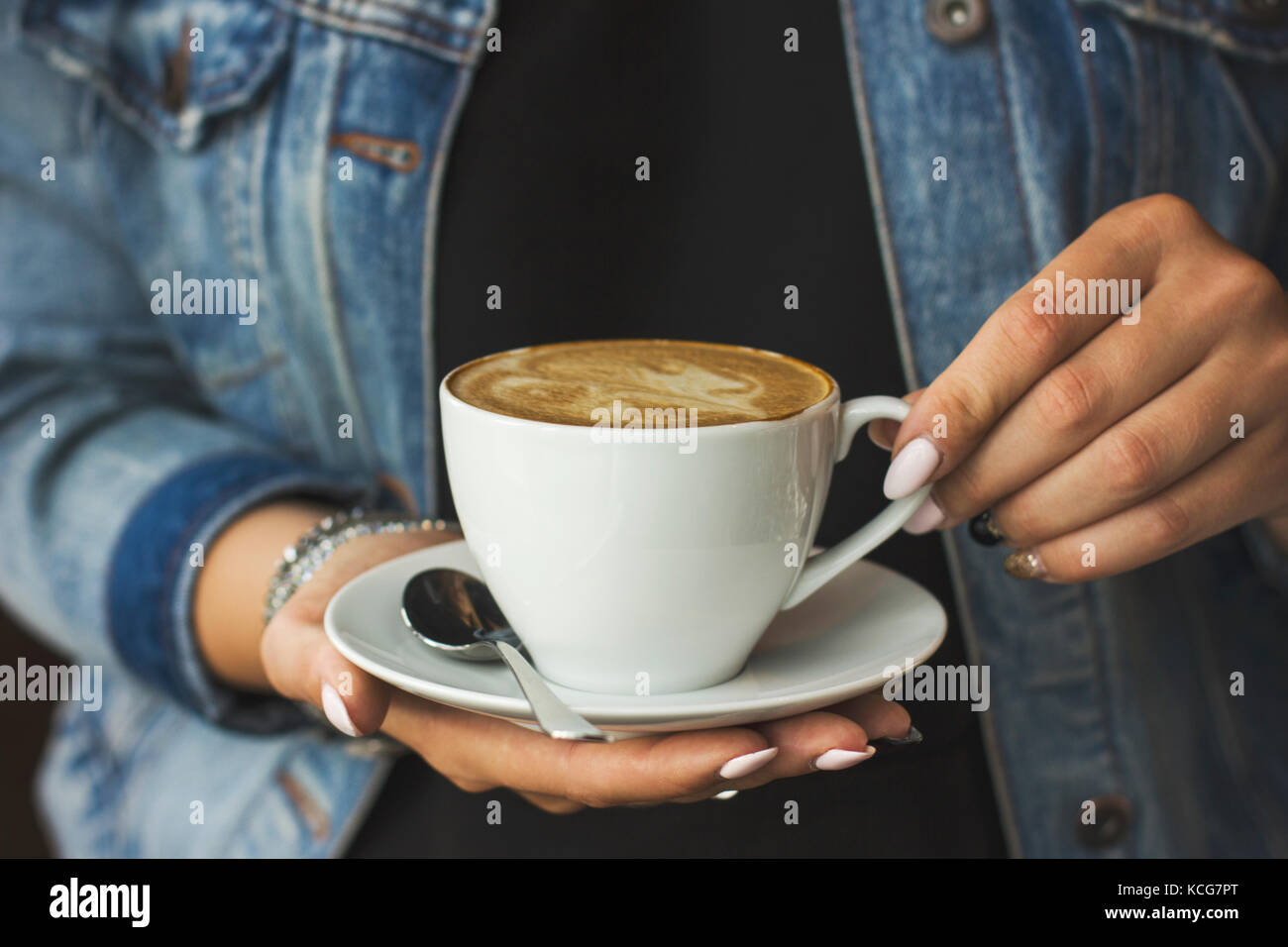 The young woman holding the cup of coffee in her hands Stock Photo - Alamy