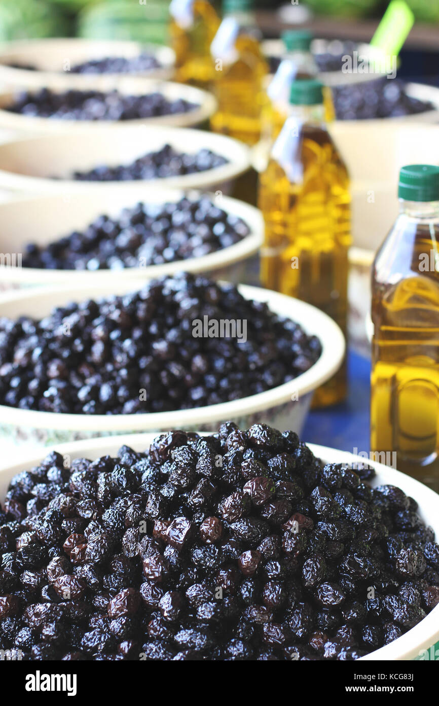Black pickle olives in bowls and bottles with olive oil at the eastern