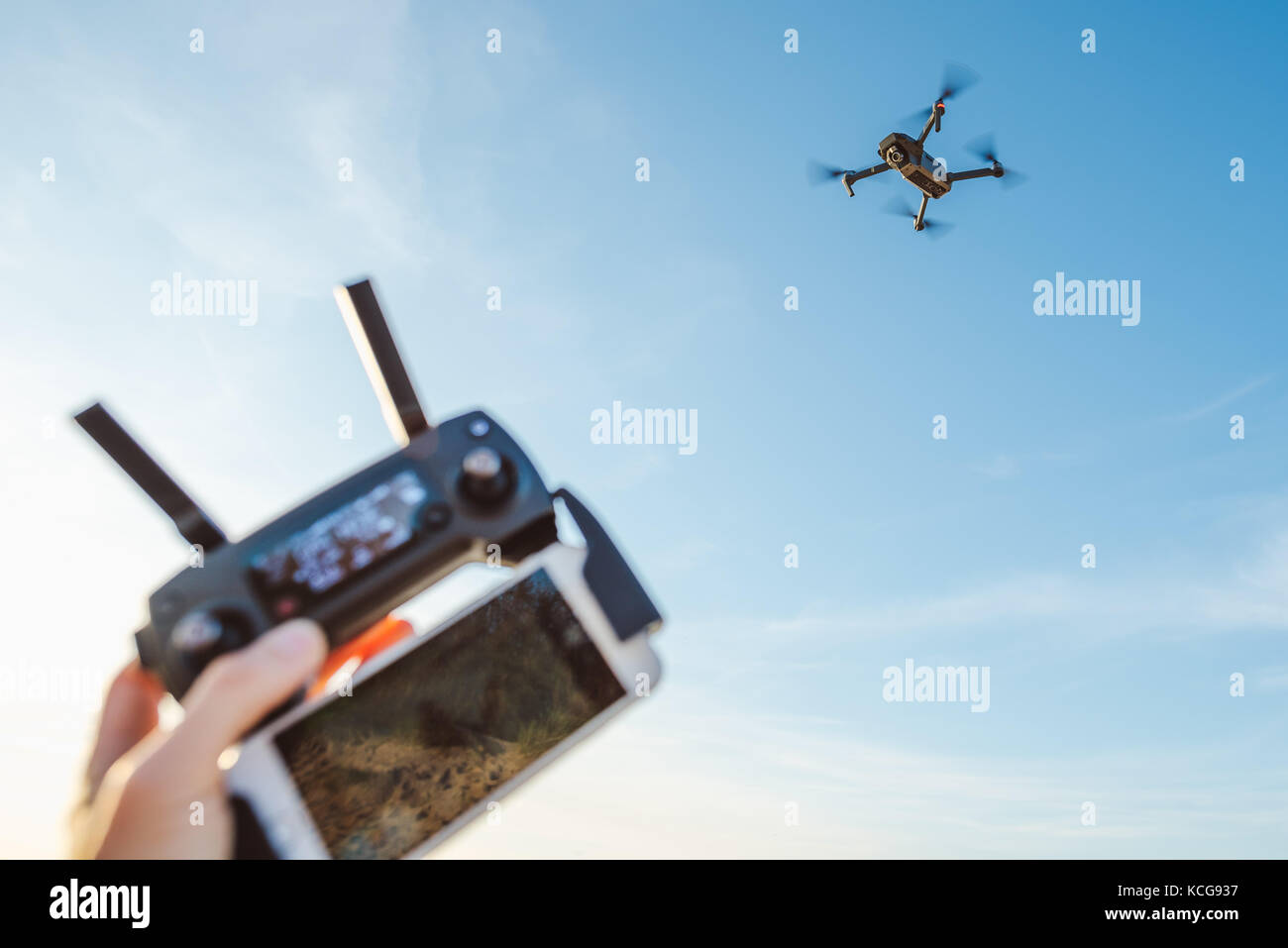 Man hand holding remote controller and using quad copter on natural background Stock Photo