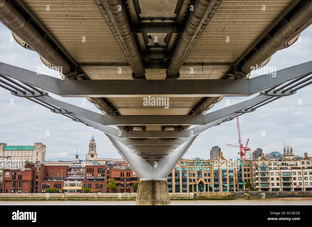Construction and architecture on show via the underside of the Millennium Bridge, a pedestrian walkway across the River Thames in London, England, UK. Stock Photo