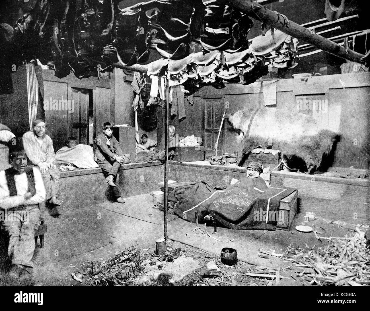 Inside an Indian hut in Yakutat Bay in Alaska, in the middle of the fire place and the family members sit or sleep distributed in the cottage, digital improved reproduction of a historical photo from the (estimated) year 1899 Stock Photo