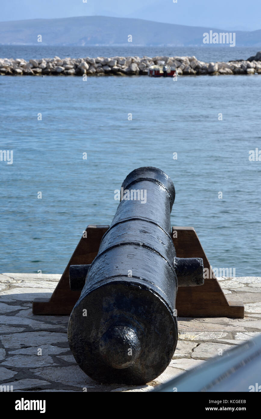 a large cannon on the quayside or the waters edge near the harbour in kassiopi in Greece on the island of corfu. Stock Photo
