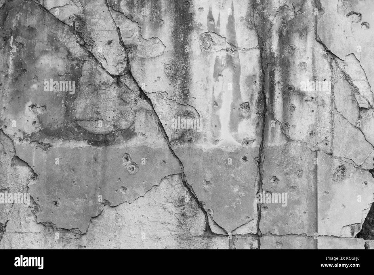 Old, damaged and cracked wall with real bullet holes from World War II in Gdansk, Poland. Background texture in black and white. Stock Photo