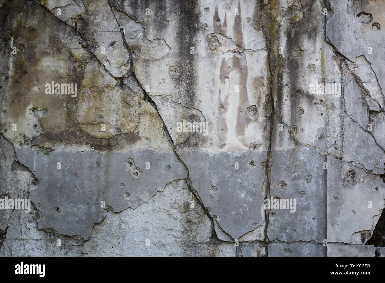 Old, damaged and cracked wall with real bullet holes from World War II in Gdansk, Poland. Background texture with vignetting. Stock Photo