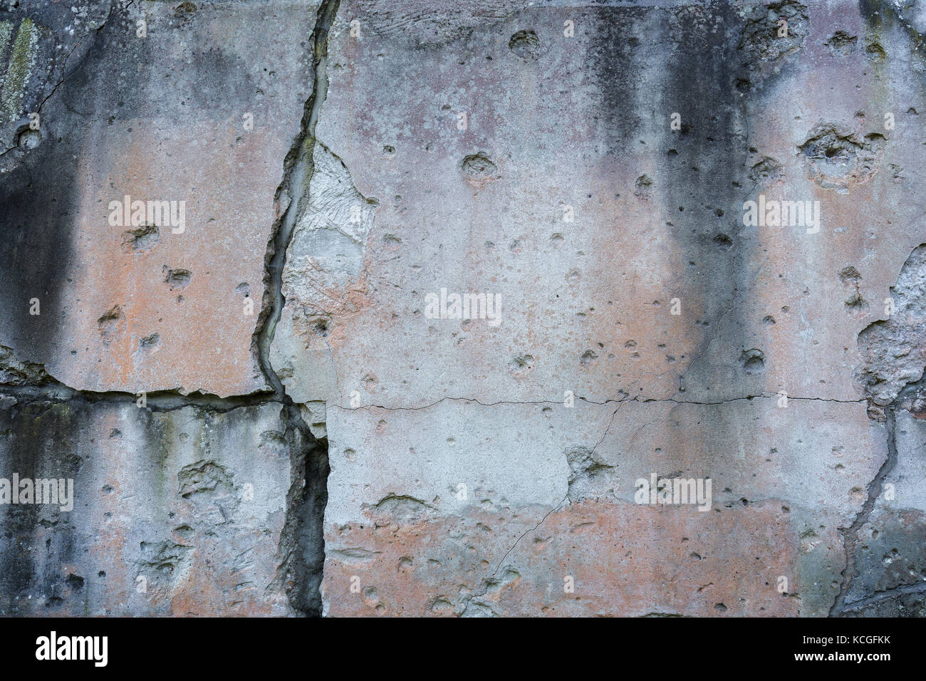 Old, damaged and cracked wall with real bullet holes from World War II in Gdansk, Poland. Background texture with vignetting. Stock Photo