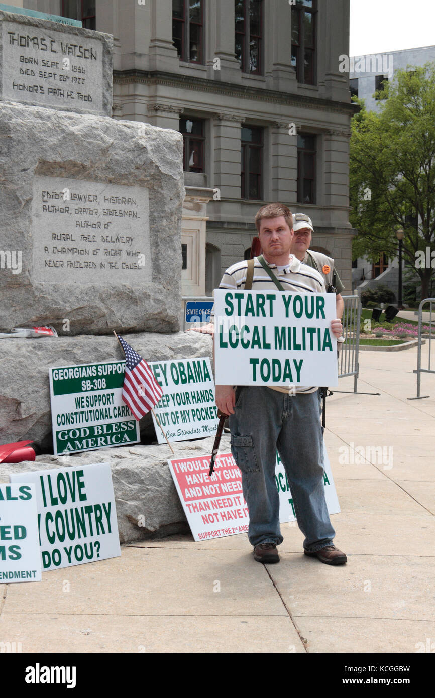 Atlanta, Georgia, 23 Apr 2011, Protester holds sign reading Start Your Local Militia Today, standing near other signs supporting gun rights Stock Photo