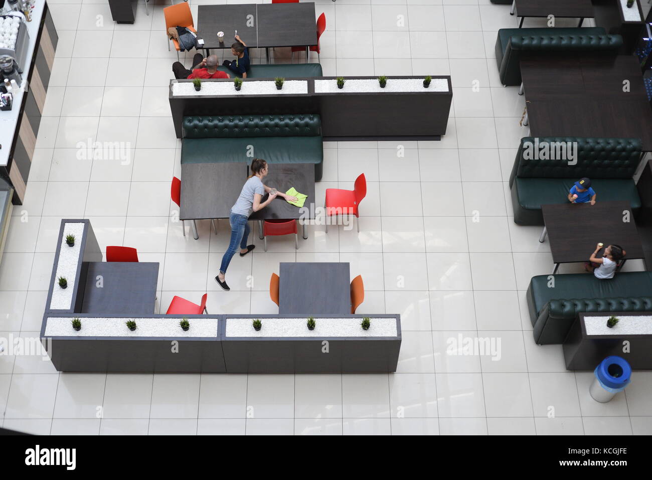 People working in a modern interior coffee bar with counters taken from overhead Stock Photo