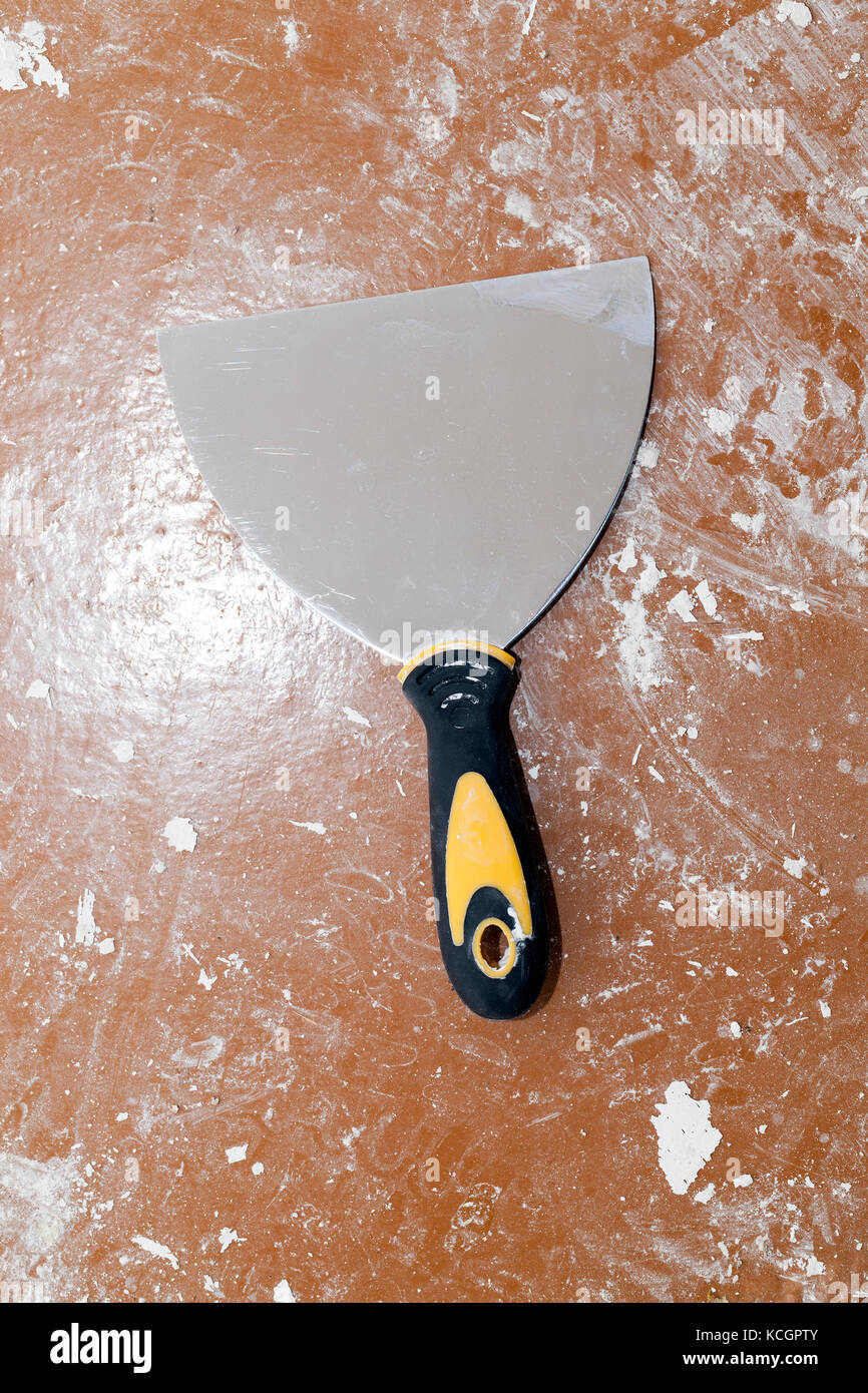 used metal spatula lying on the floor for construction work Stock Photo