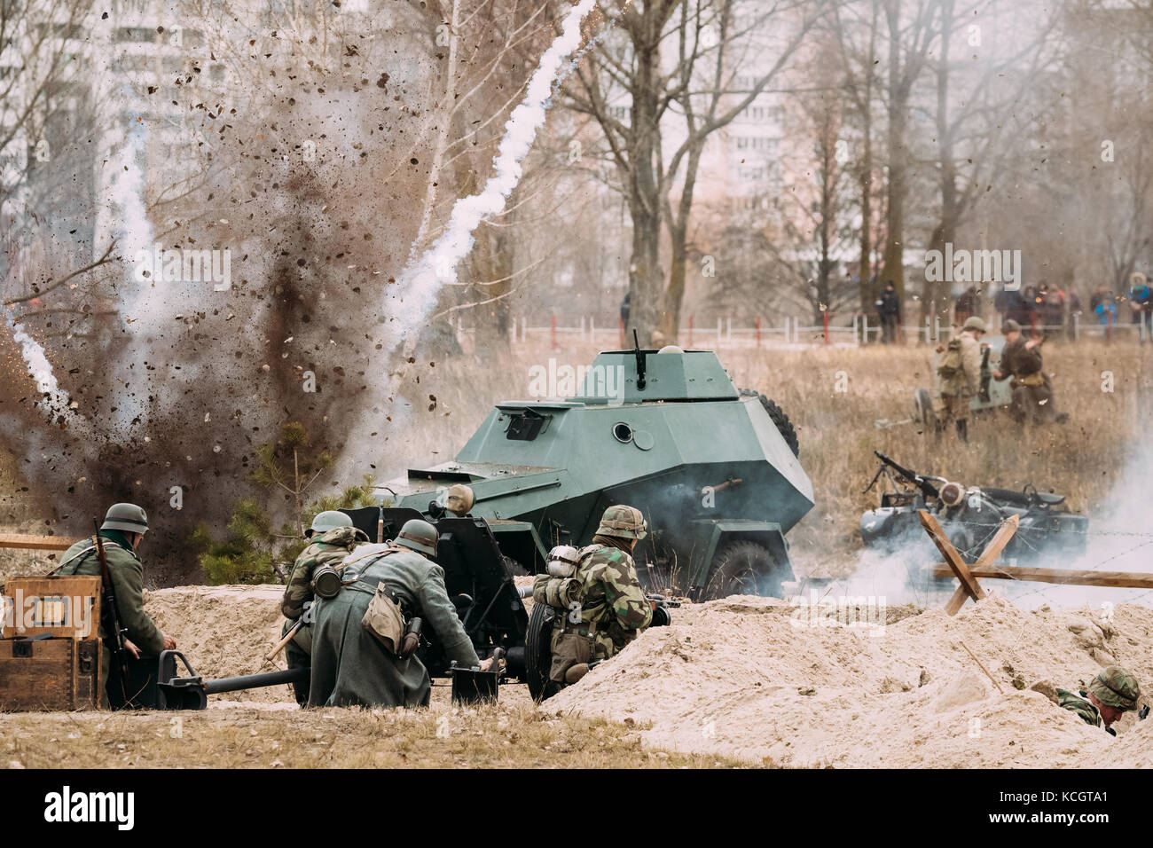 Re-enactors Dressed As German Soldiers In World War II Are Fighting Shooting With A Cannon On The Russian Soviet Armored Car During Historical Reenact Stock Photo