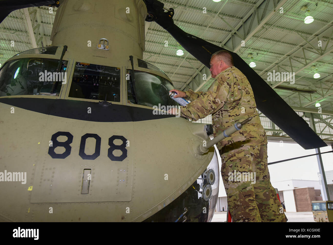 U.S. Army Master Sgt. Gary Server, a first sergeant from the Ohio National Guard’s 3-238th General Aviation Support Battalion, cleans the windows on a Boeing CH-47F Chinook aircraft at McEntire Joint National Guard Base, S.C., before it continues on to Naval Air Station Cecil Field in Jacksonville, Florida as part of a response to Hurricane Irma, Sept. 12, 2017.  McEntire JNGB served as a transition point for the unit to refuel before heading on to Florida. Both aircraft recently responded to the damage and flooding in Texas caused by Hurricane Harvey by moving supplies and personnel. Hurrican Stock Photo