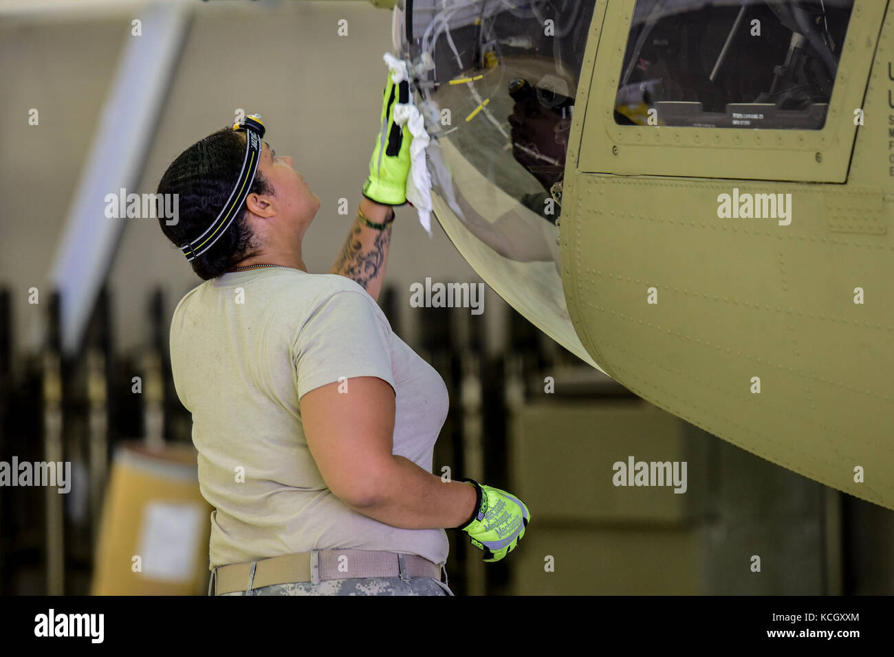 U.S. Army Specialist Pamela Howe, an aircraft mechanic from the Ohio National Guard’s 3-238th General Aviation Support Battalion, washes the windows on a Boeing CH-47F Chinook aircraft at McEntire Joint National Guard Base, S.C., before it continues on to Naval Air Station Cecil Field in Jacksonville, Florida as part of a response to Hurricane Irma, Sept. 12, 2017.  McEntire JNGB served as a transition point for the unit to refuel before heading on to Florida. Both aircraft recently responded to the damage and flooding in Texas caused by Hurricane Harvey by moving supplies and personnel. Hurri Stock Photo