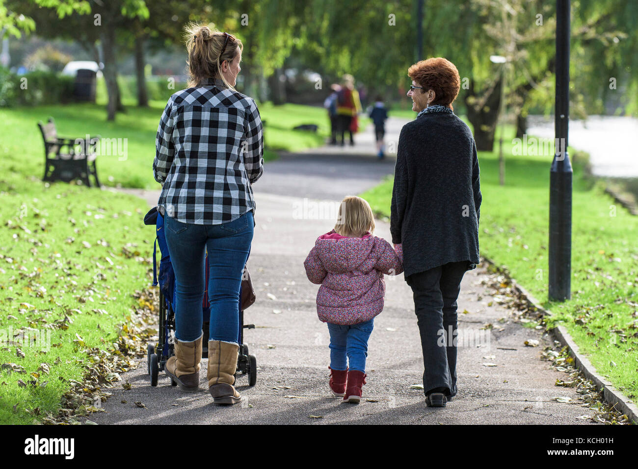 A grandmother, daughter and granddaughter enjoying a stroll in the sunshine. Stock Photo