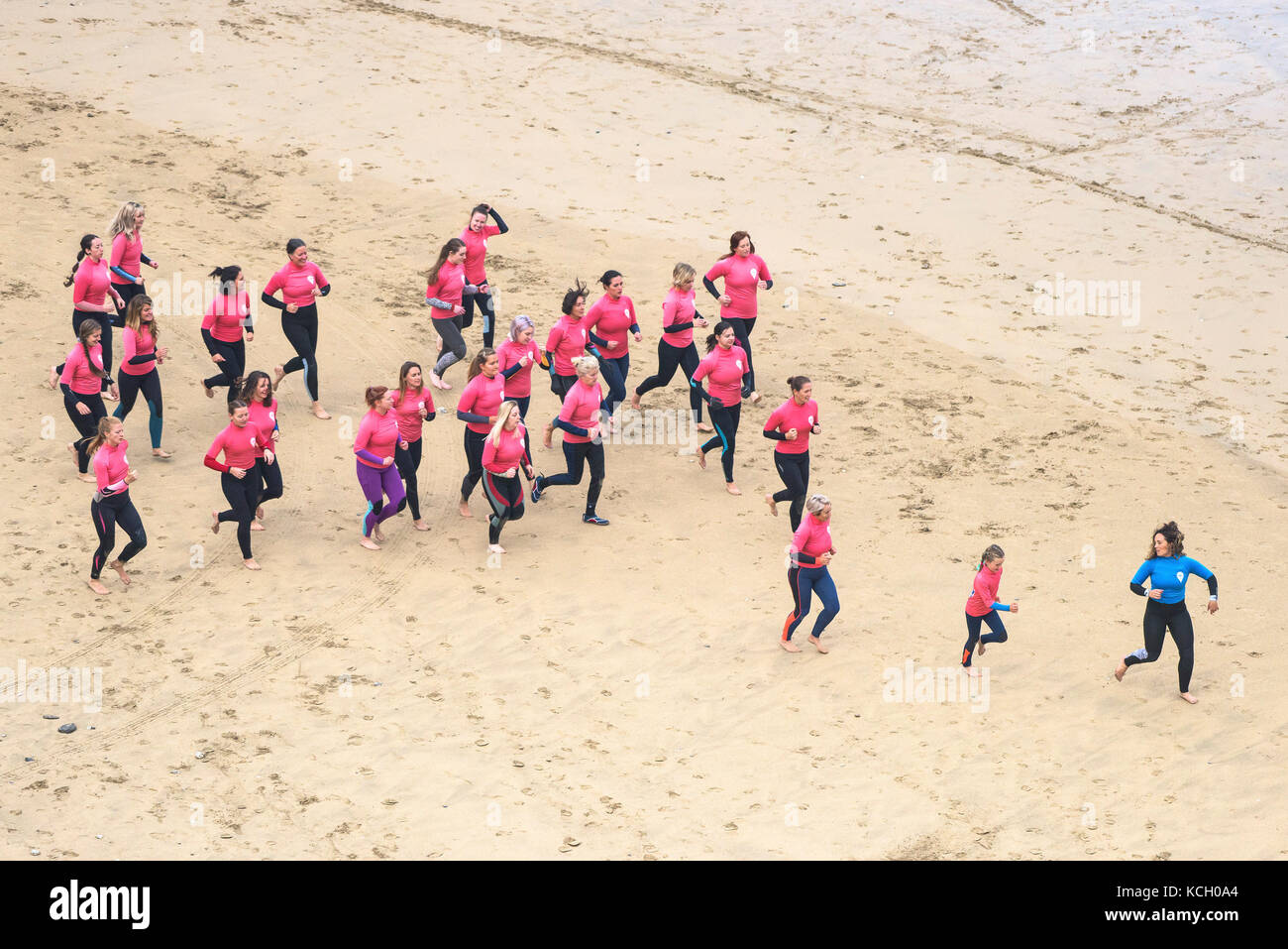 Surf beginners warming up with their instructor. Surf Betty’s Festival - a festival held in Newquay to help empower women through surfing and fitness. Stock Photo