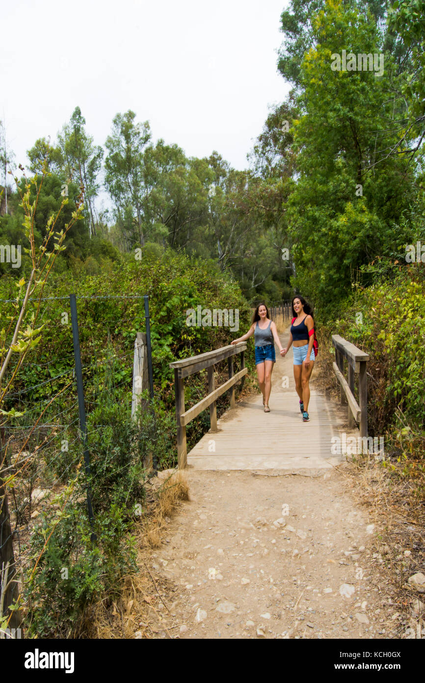 Two beautiful women hiking in nature on a mountain road Stock Photo - Alamy