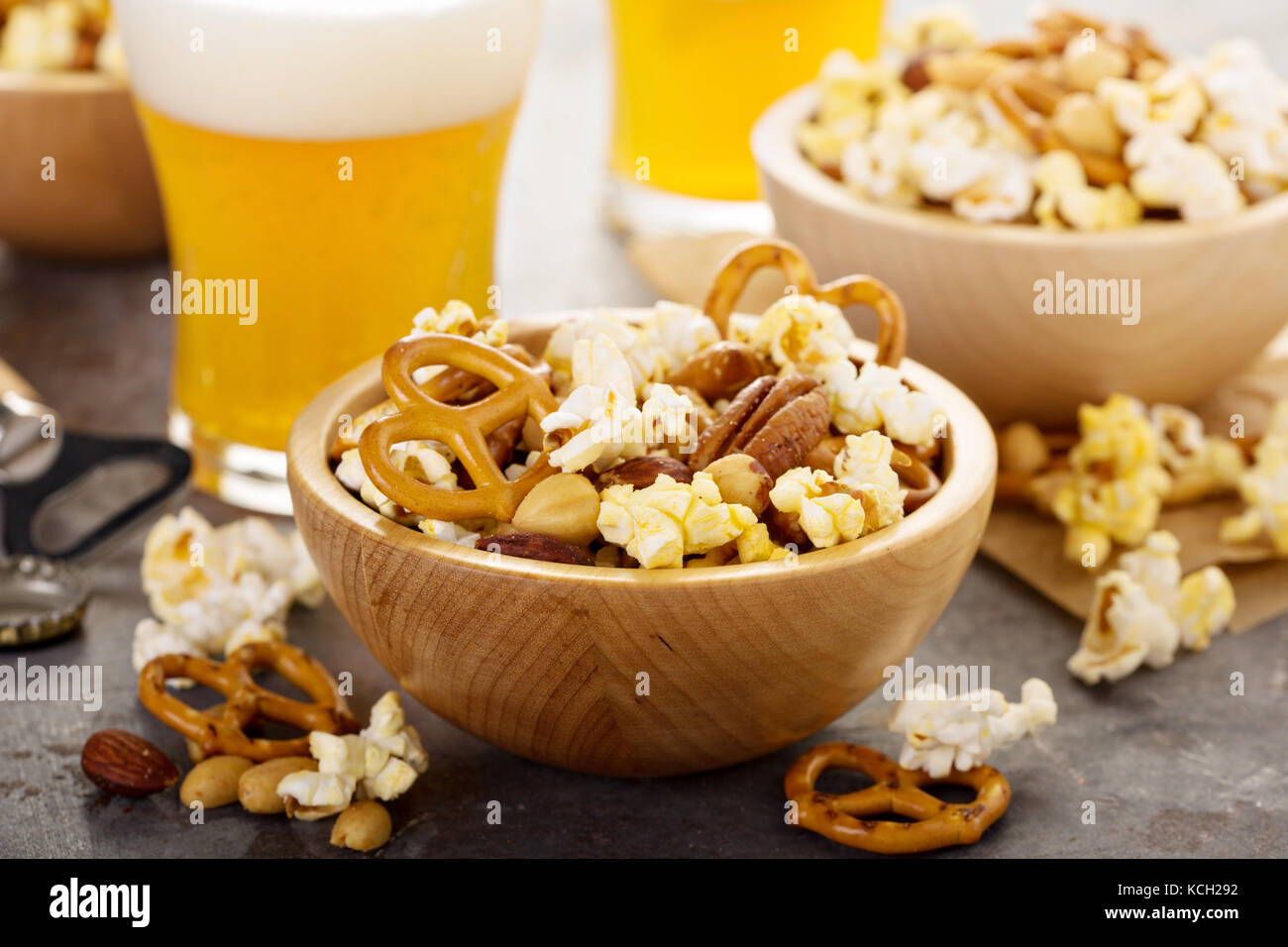 Homemade trail or snack mix with popcorn, pretzels and nuts with beer
