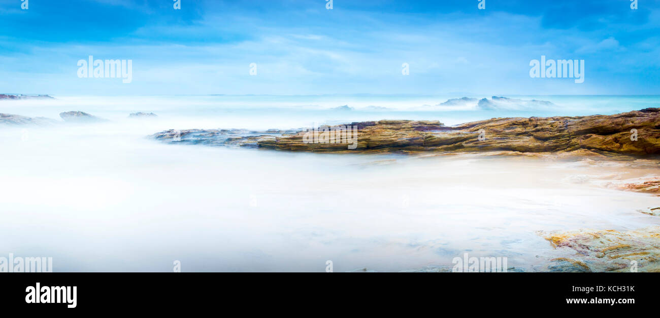Calm ocean landscape time-lapse with smooth waves and rocks Stock Photo