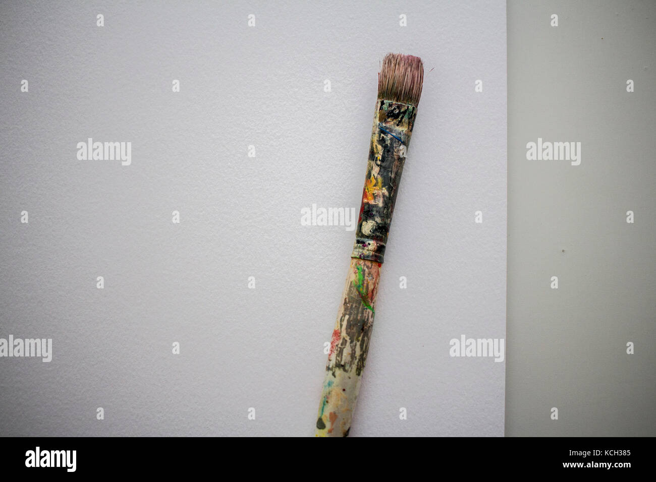 A wellused paint brush, covered in layers of dried paint, resting on a