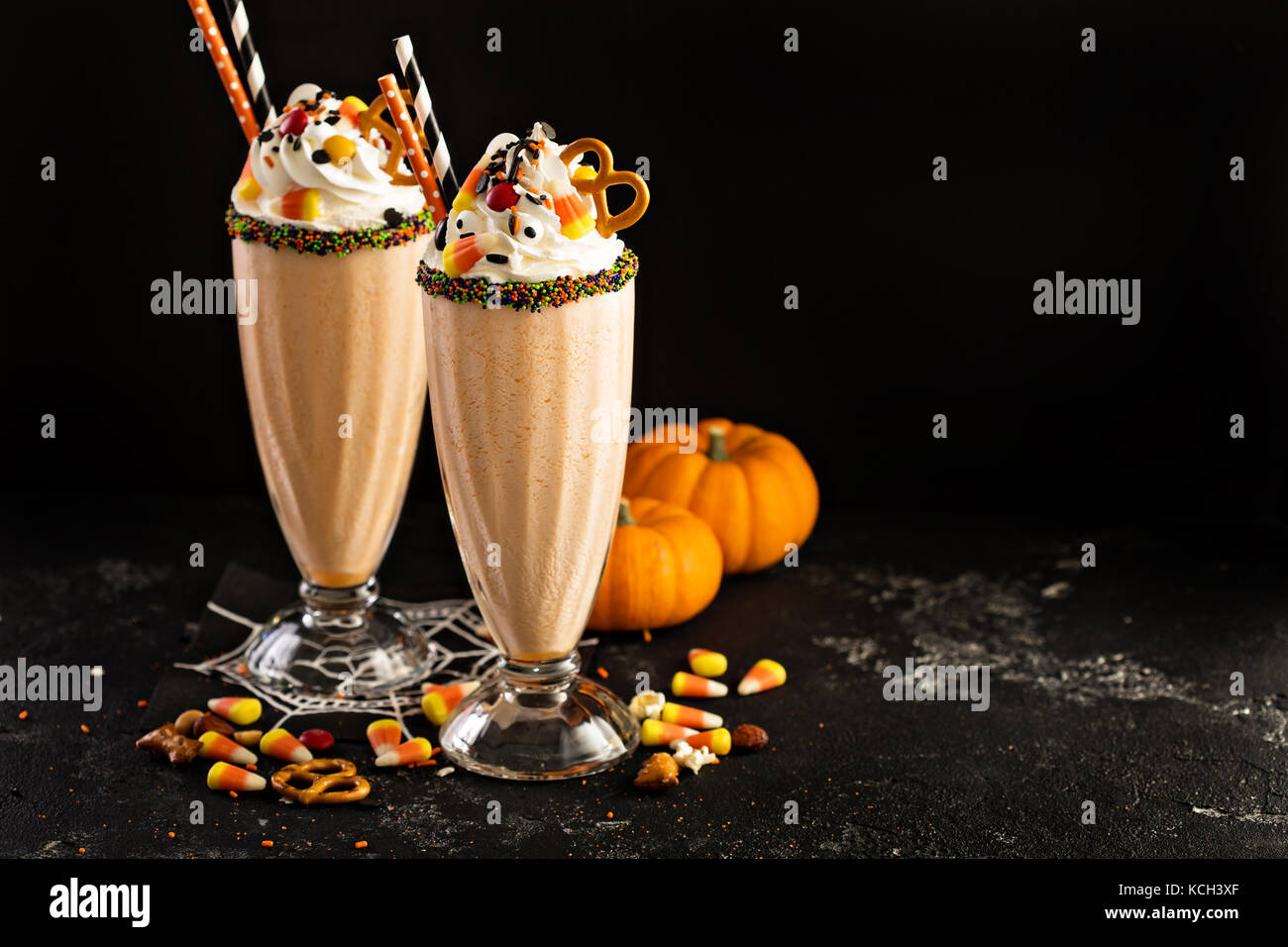 Halloween pumpkin milkshake decorated with candy Stock Photo