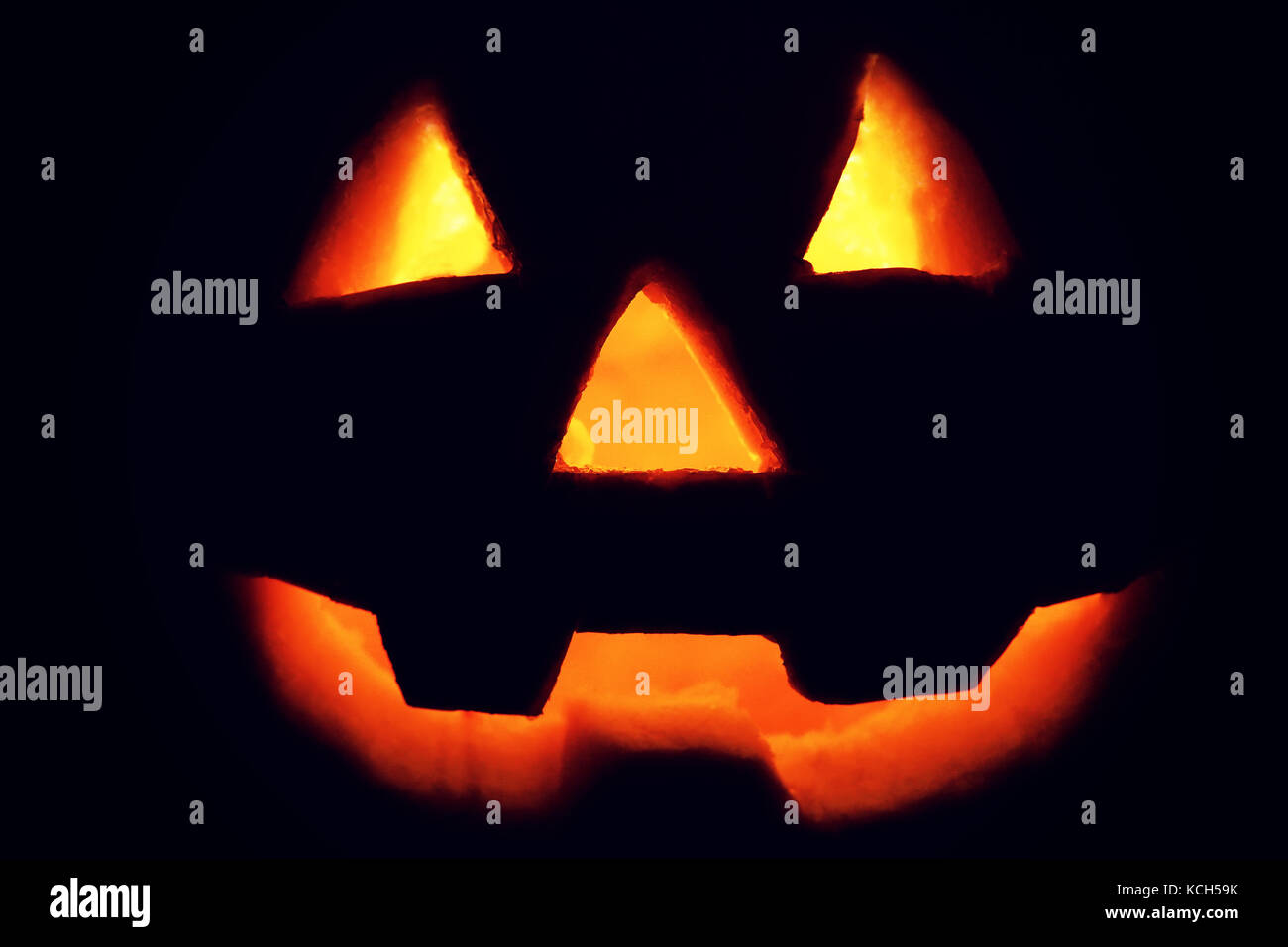 Jack-o'-lantern silhouette on black background. Glowing Jack-o'-lantern pumpkin in dark. Halloween background. Stock Photo