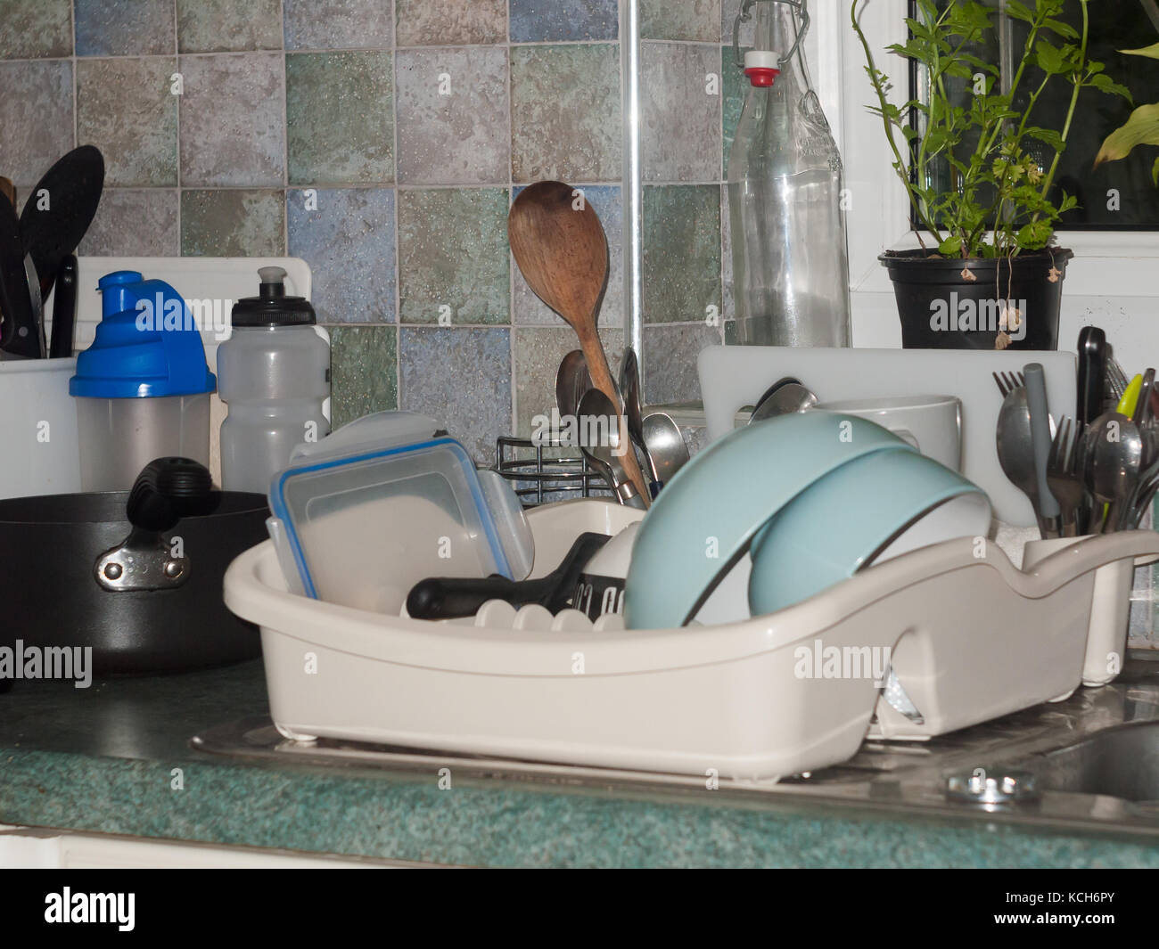 washed and drying cutlery on side on sink in kitchen scene; essex