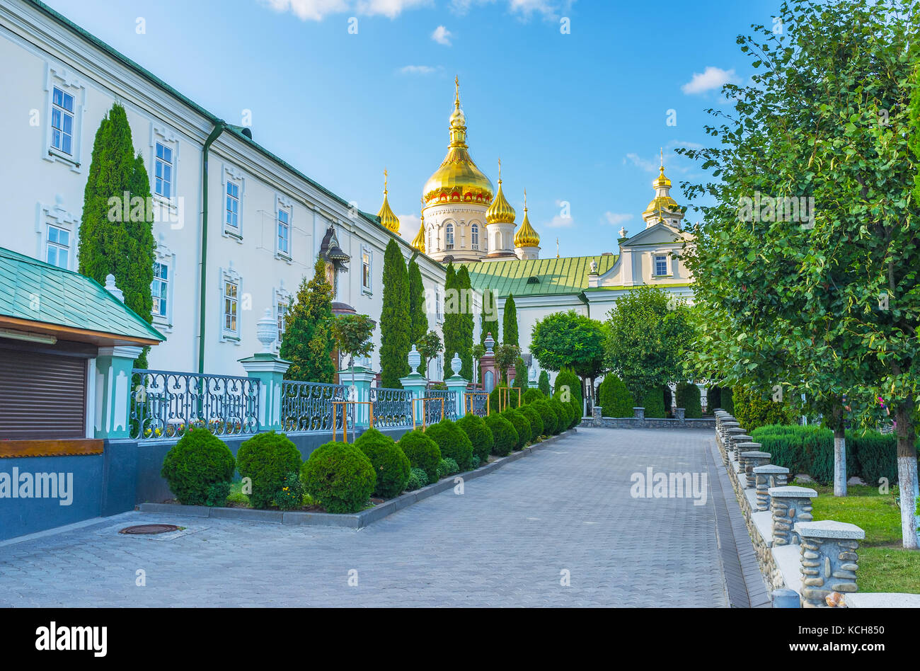 The courtyard of brotherhood's corps with narrow alley surrounded with monastery garden, Pochaev, Ukraine Stock Photo