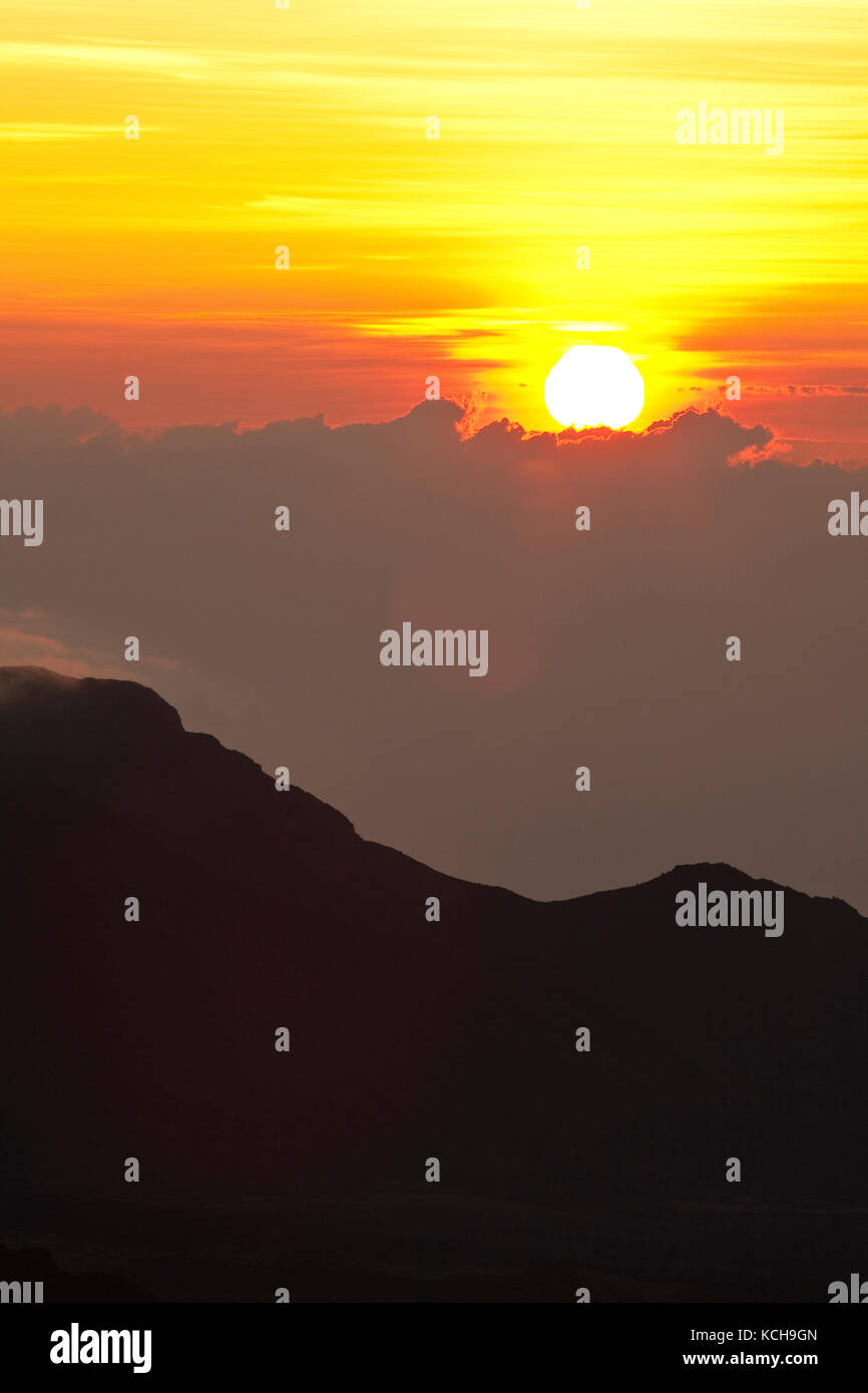 Sun rising above clouds, Haleakala National Park, Maui, Hawaii Stock
