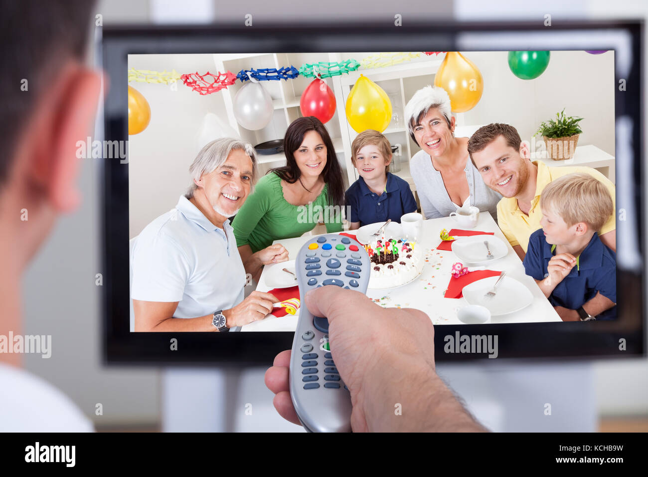 Close up of hand changing television channel through remote Stock Photo