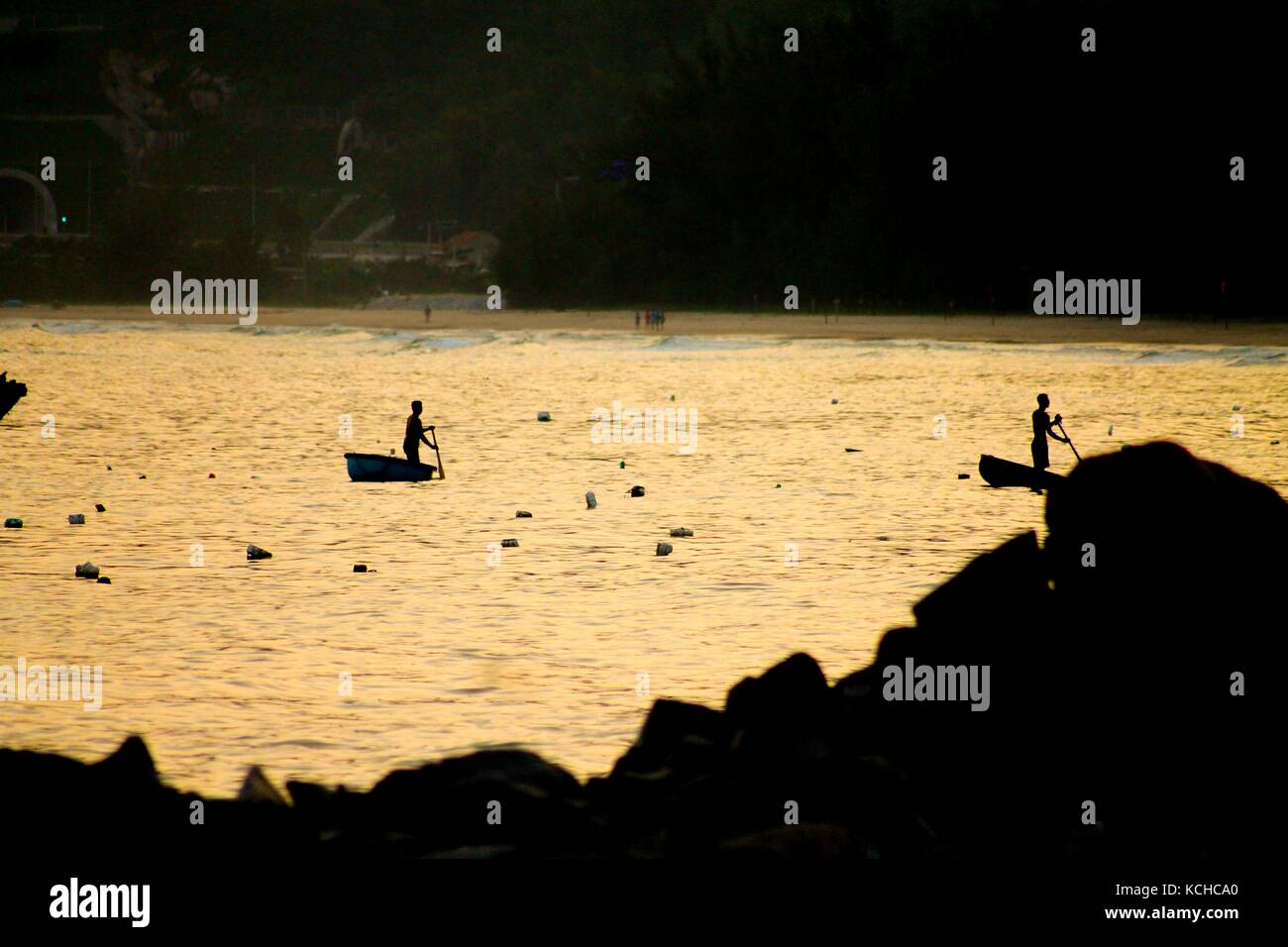 Silhouettes of fishermen in the sunset Stock Photo - Alamy