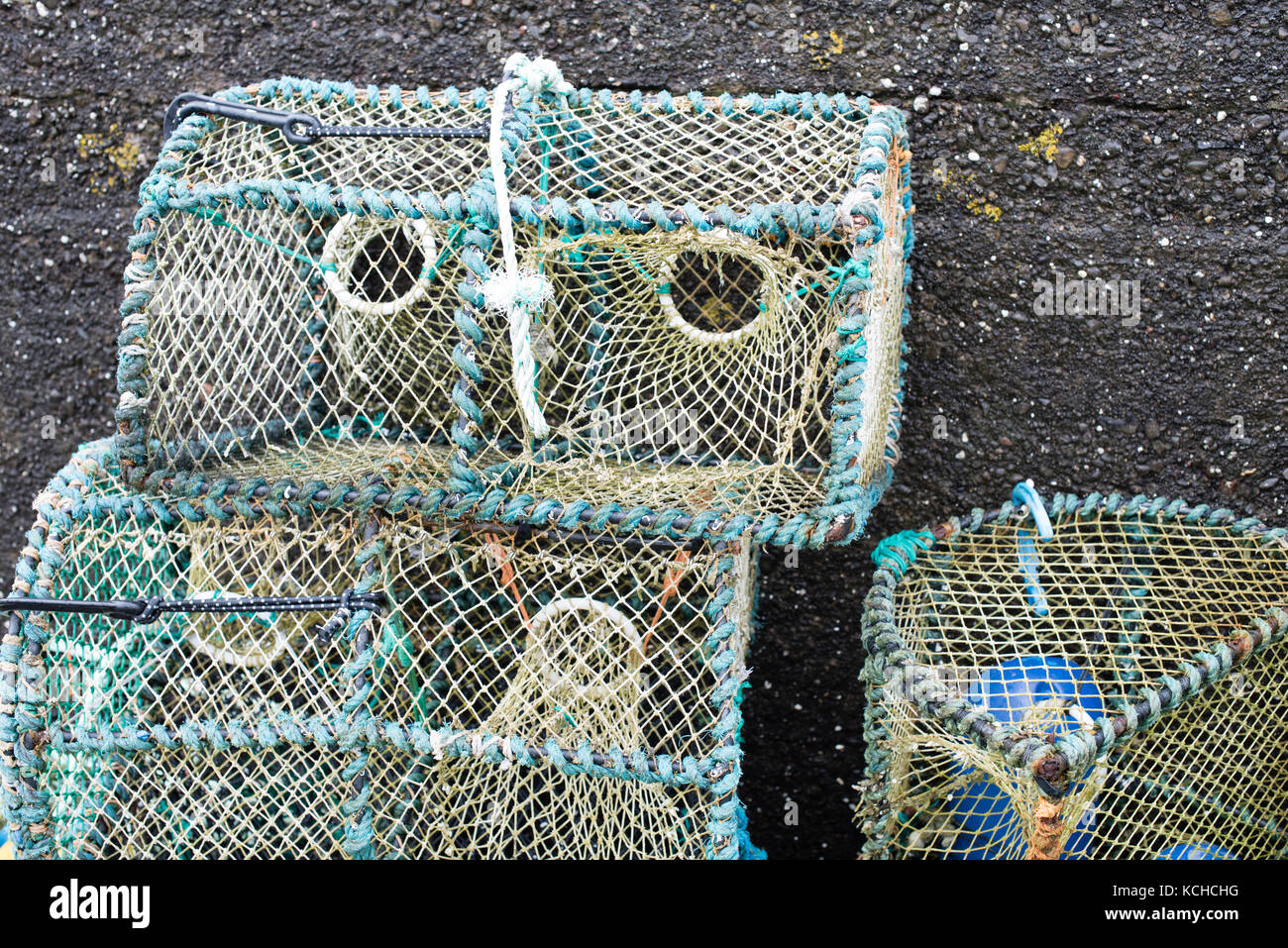 Lobster creels stacked against the harbour wall at Lower Milovaig Stock Photo
