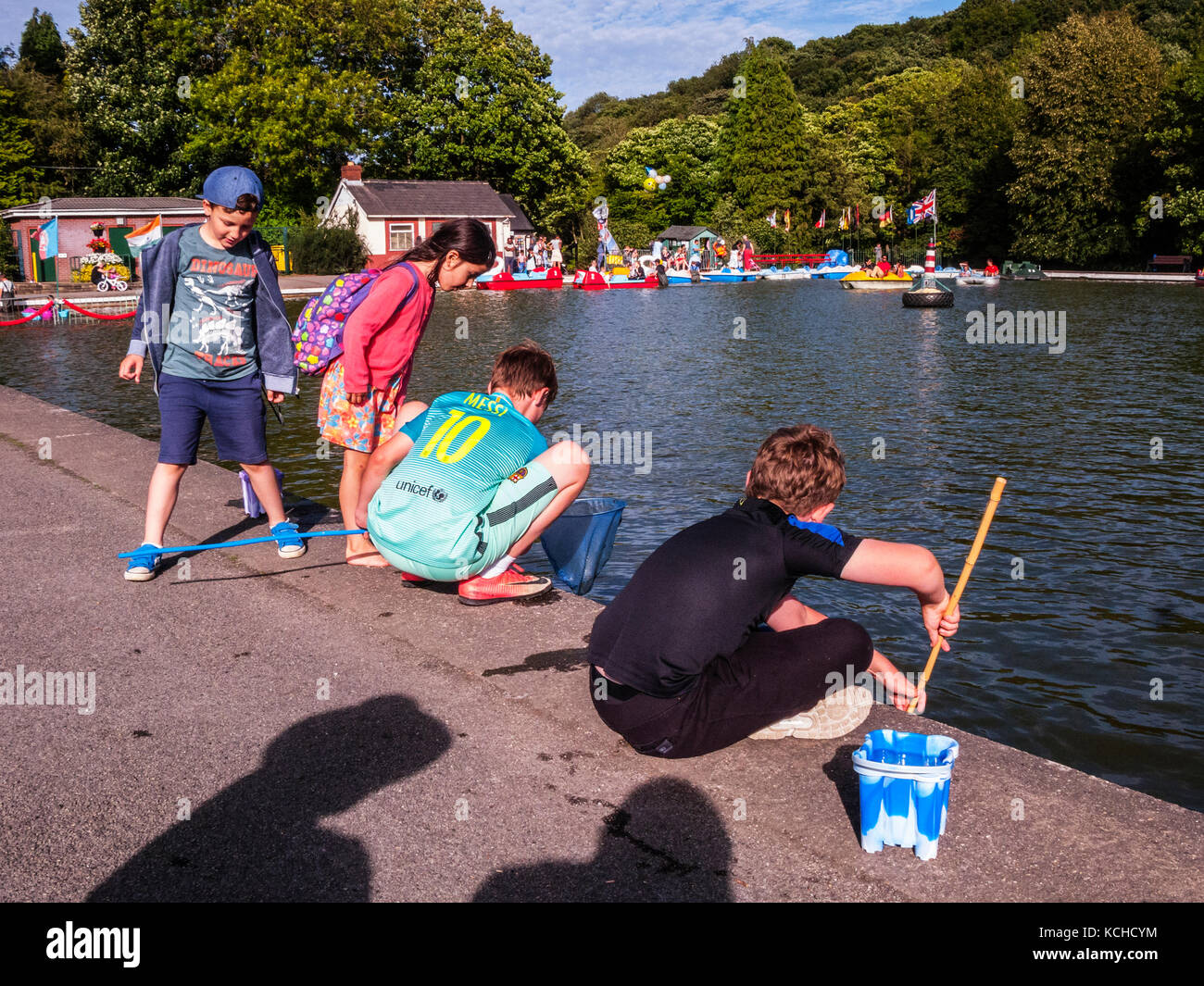 2 Boys fishing for newts in boating lake Stock Photo