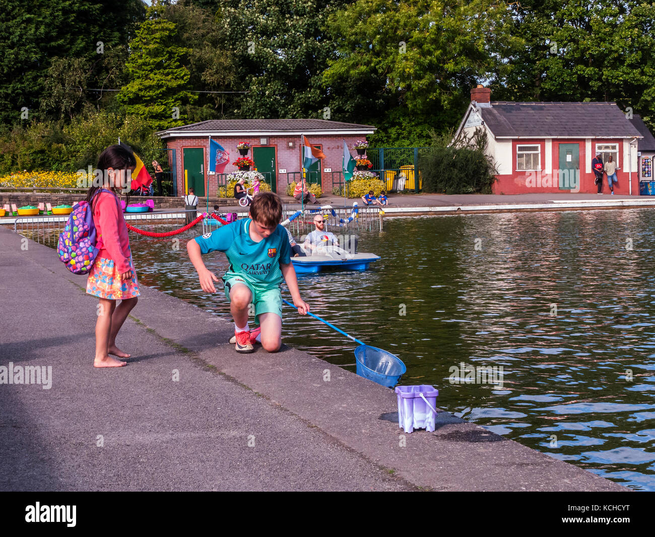 Boy, 10 years, fishing for newts in boating lake Stock Photo