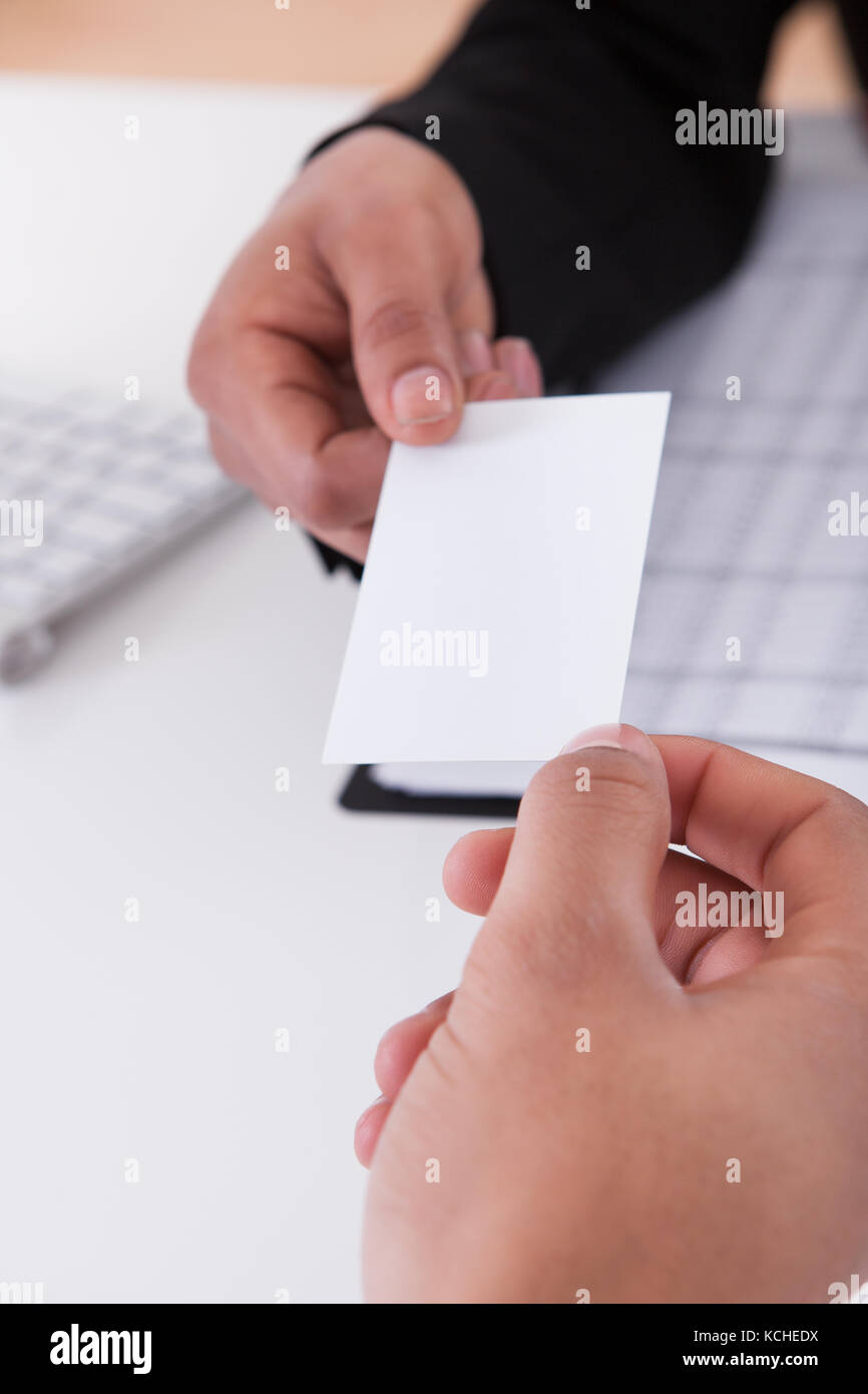 Close-up Of Business Hands Giving Visiting Card To Partner Stock Photo