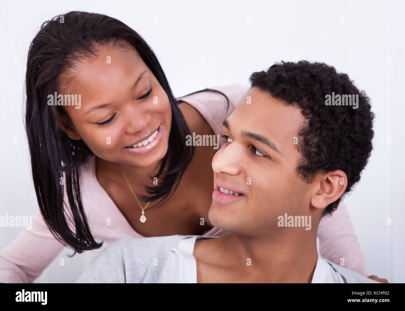 Portrait Of Woman Whispering To Boyfriend's Ear Stock Photo