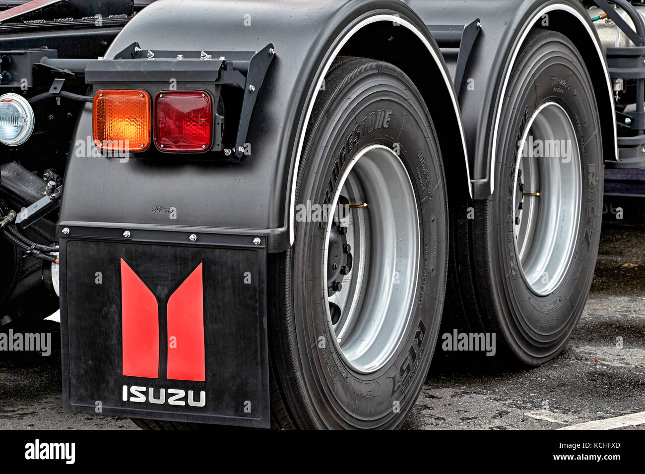 Detail of a new modern Isuzu large 6 wheeled truck. Wheel, tire, tyre. Close up. Stock Photo