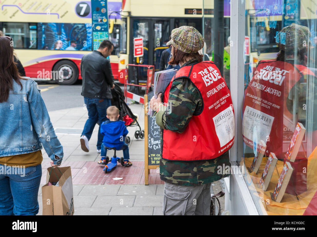 Woman on the streets as an official vendor of the Big Issue magazine in Brighton, East Sussex, England, UK. Stock Photo