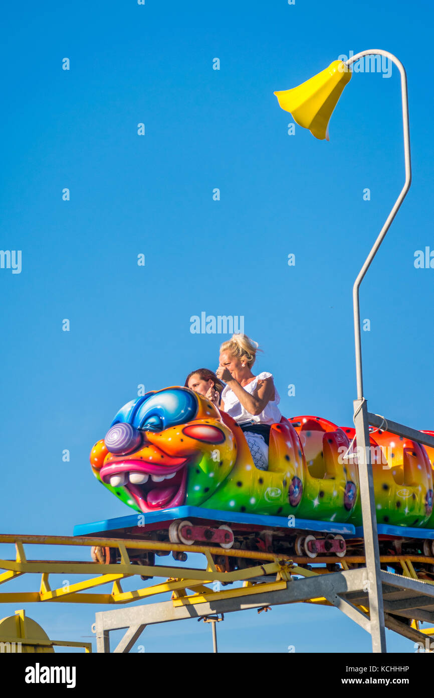 Mother and daughter share a fairground ride on brightly coloured