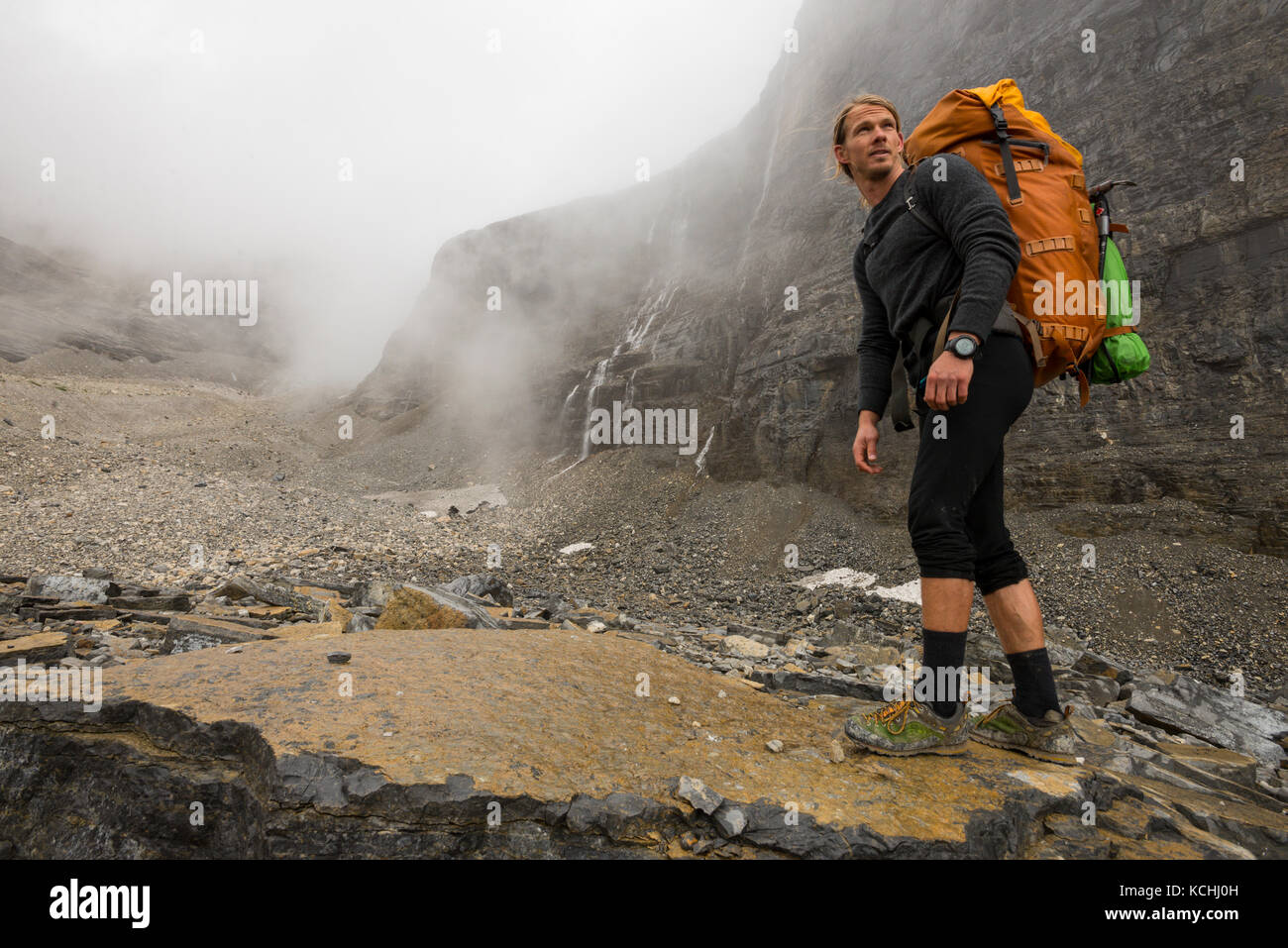 A hiker in alpine talus on the lower flanks of Mount Assiniboine, British Columbia Stock Photo