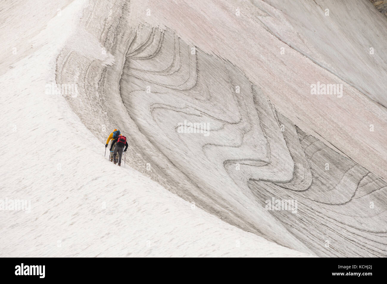 Two climbers ascend a snow slope while heading up Mt. Strom in Assiniboine Provincial Park, BC Stock Photo