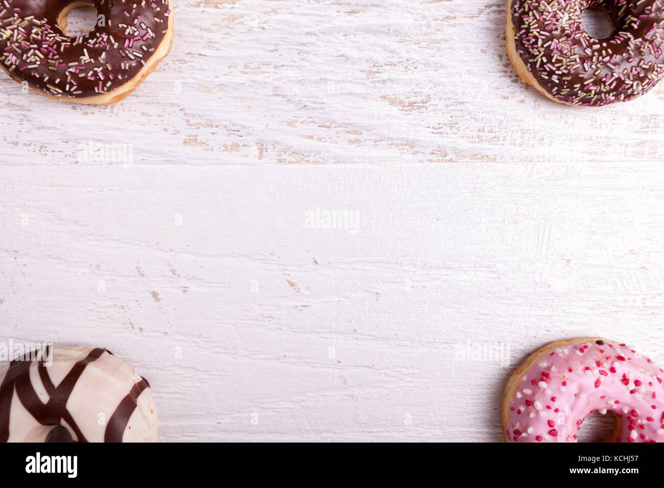 Different type of donuts on white wooden background Stock Photo - Alamy