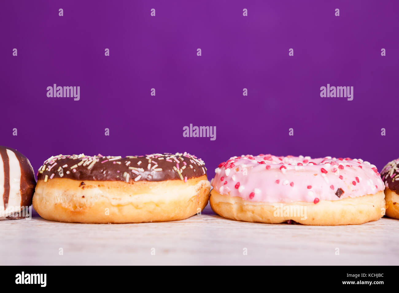Different type of donuts on white wooden background Stock Photo - Alamy